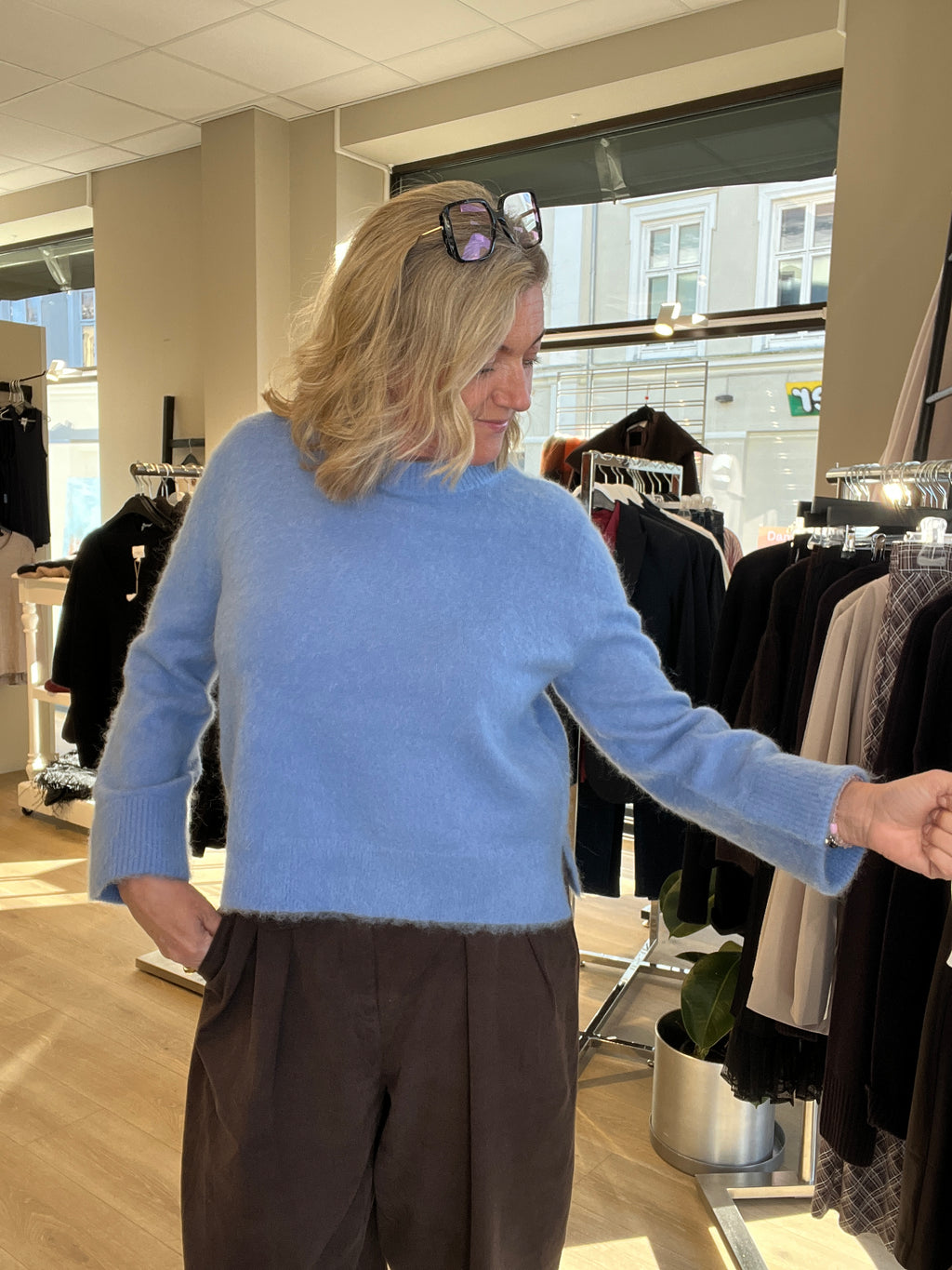 Alma Kari genser i blå børstet mohair til dame, sett forfra med brun bukse
