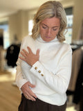 Genser med liten hals og gullknapper på cuff