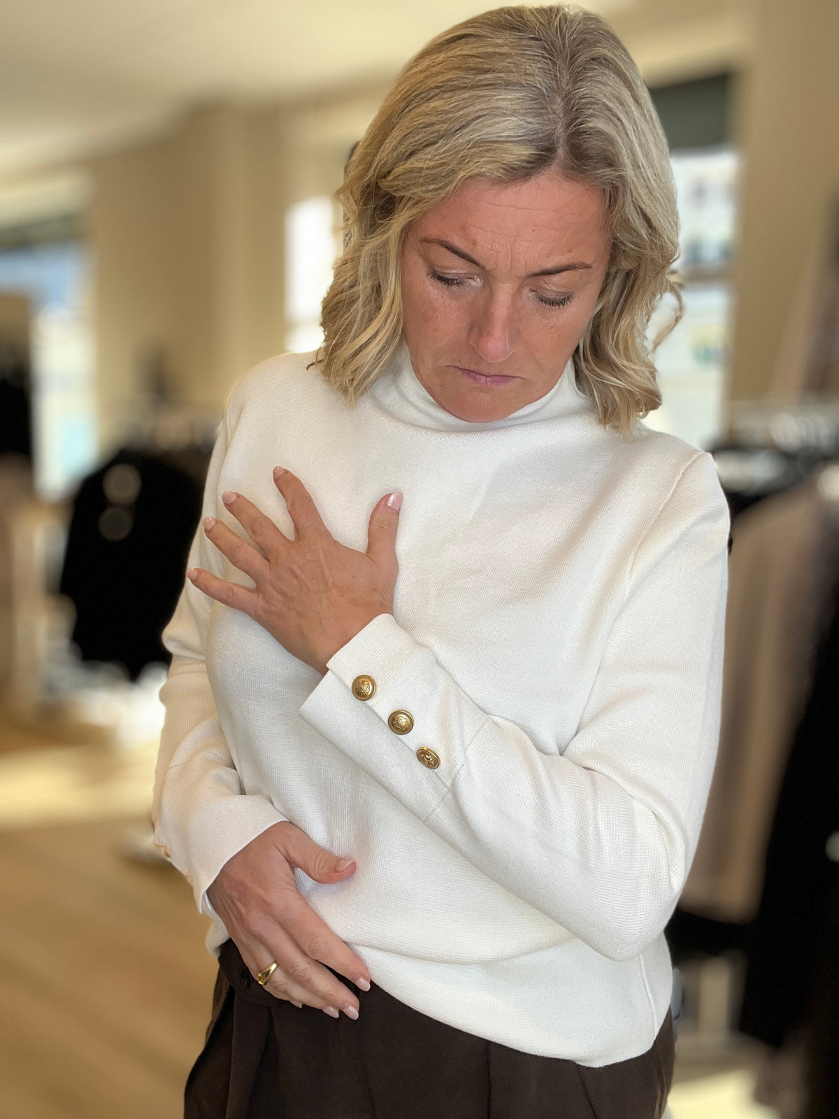 Genser med liten hals og gullknapper på cuff